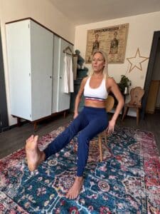 posture de yoga sur chaise avec une jambe tendue